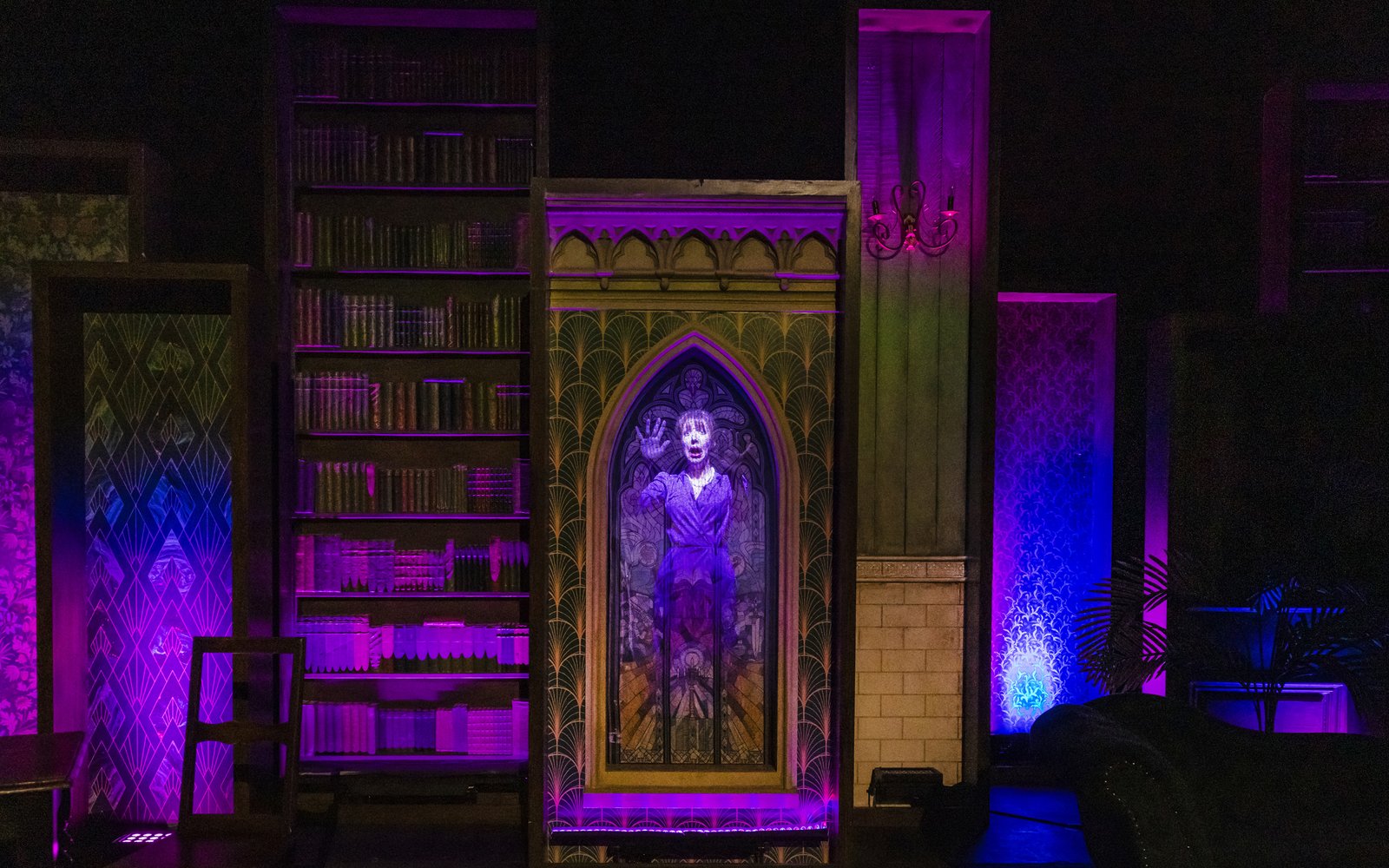A woman in a purple dress is trapped behind a stained glass window, looking scared with her hands on the glass.