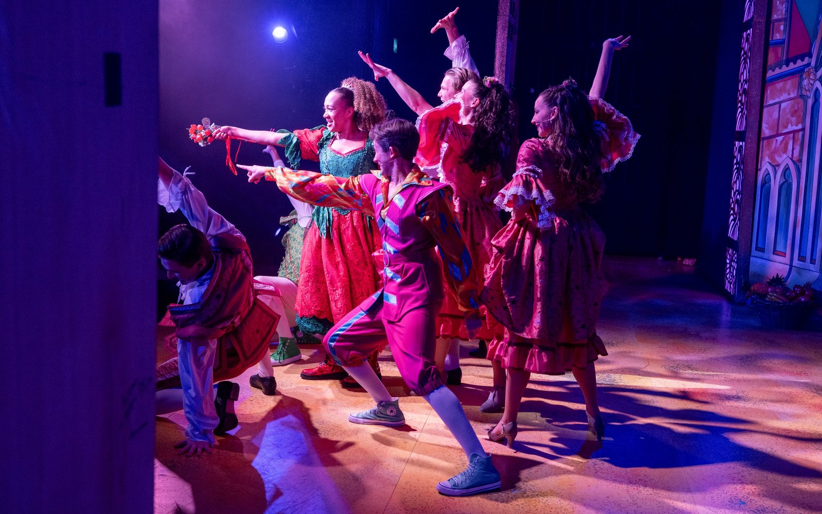 Fairy Strawberry, Happy Harry and the ensemble of Sleeping Beauty are lit by a spotlight, striking a pose towards the audience at the end of a dance.