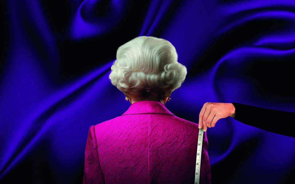 The Queen stands in a pink jacket whilst someone measures her with a measuring tape