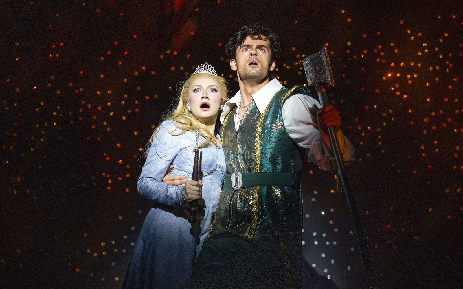 Princess Rose and Prince Ken hold each other looking scared, she is wearing a sparkly tiara and he is carrying a sparkly axe