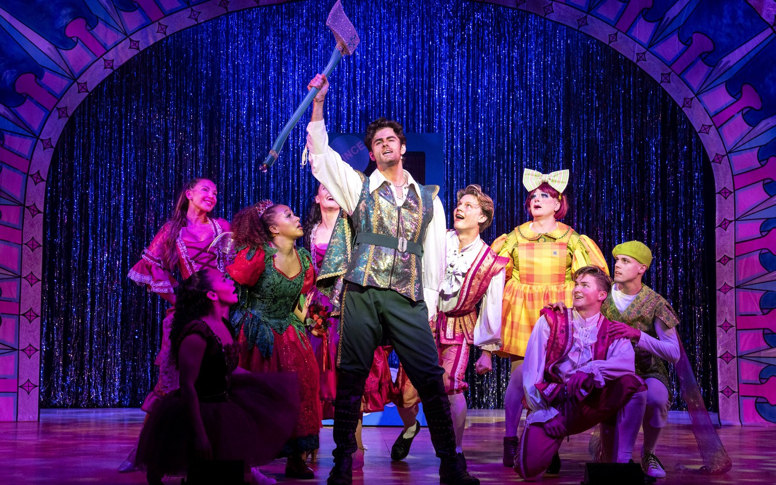 Prince Ken stands holding an axe in the air, everyone around him looks up in awe