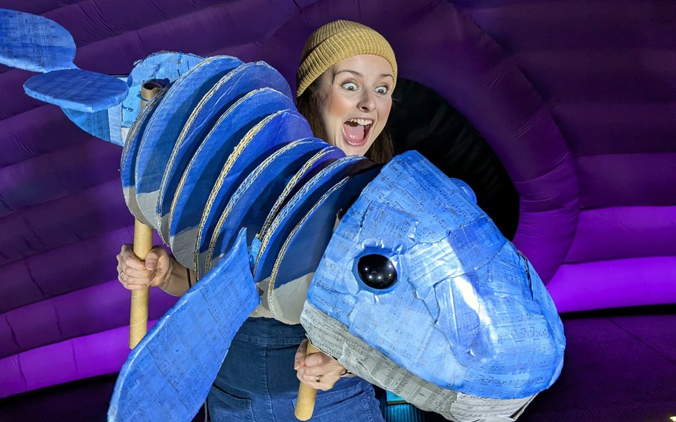 A woman wears a costume that looks like a blue whale