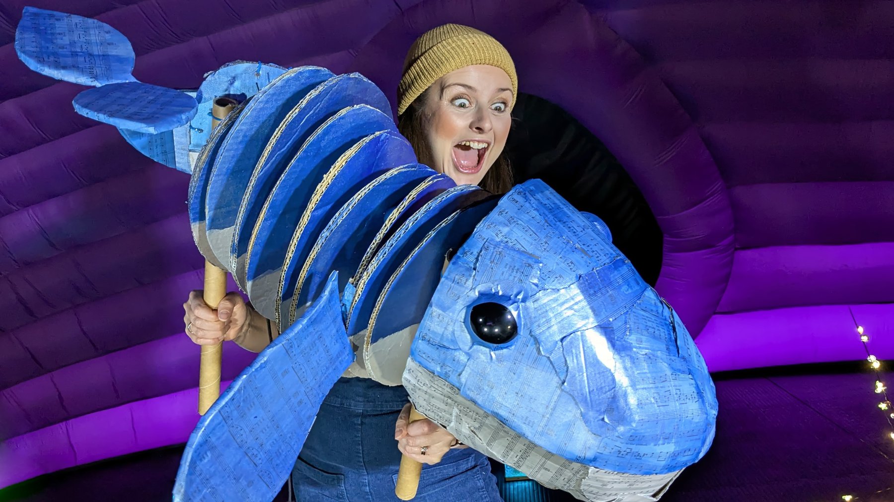 A woman wears a costume that looks like a blue whale