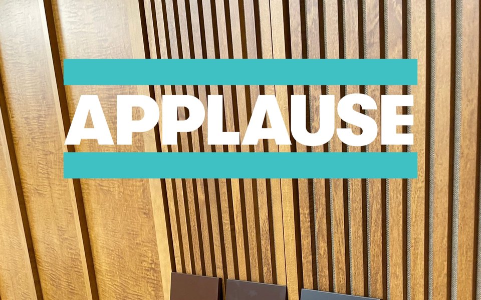 The new wood panelling in TATC's auditorium, the image overlayed with the word 'APPLAUSE'