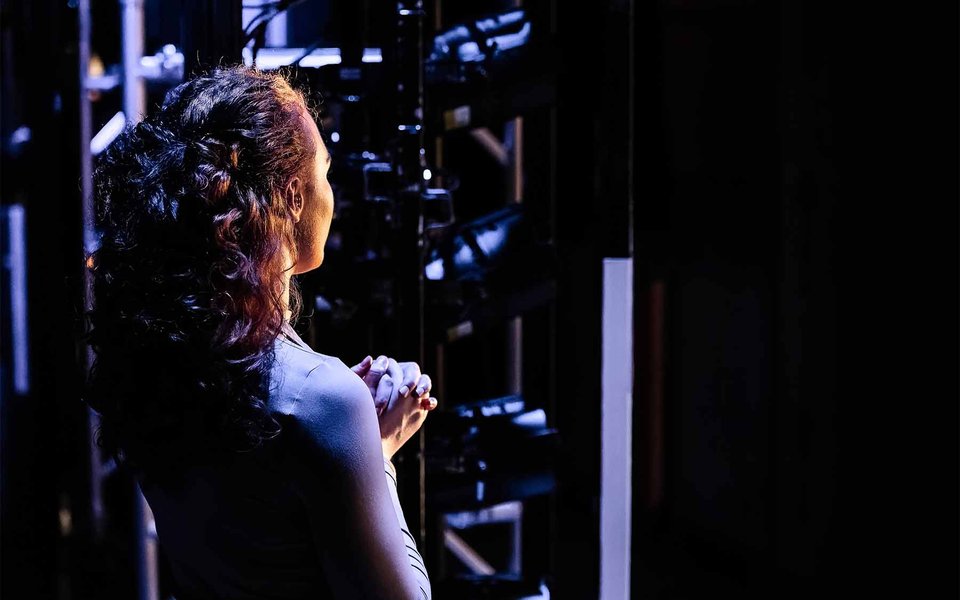 A portrait of a woman facing away from the camera in thought