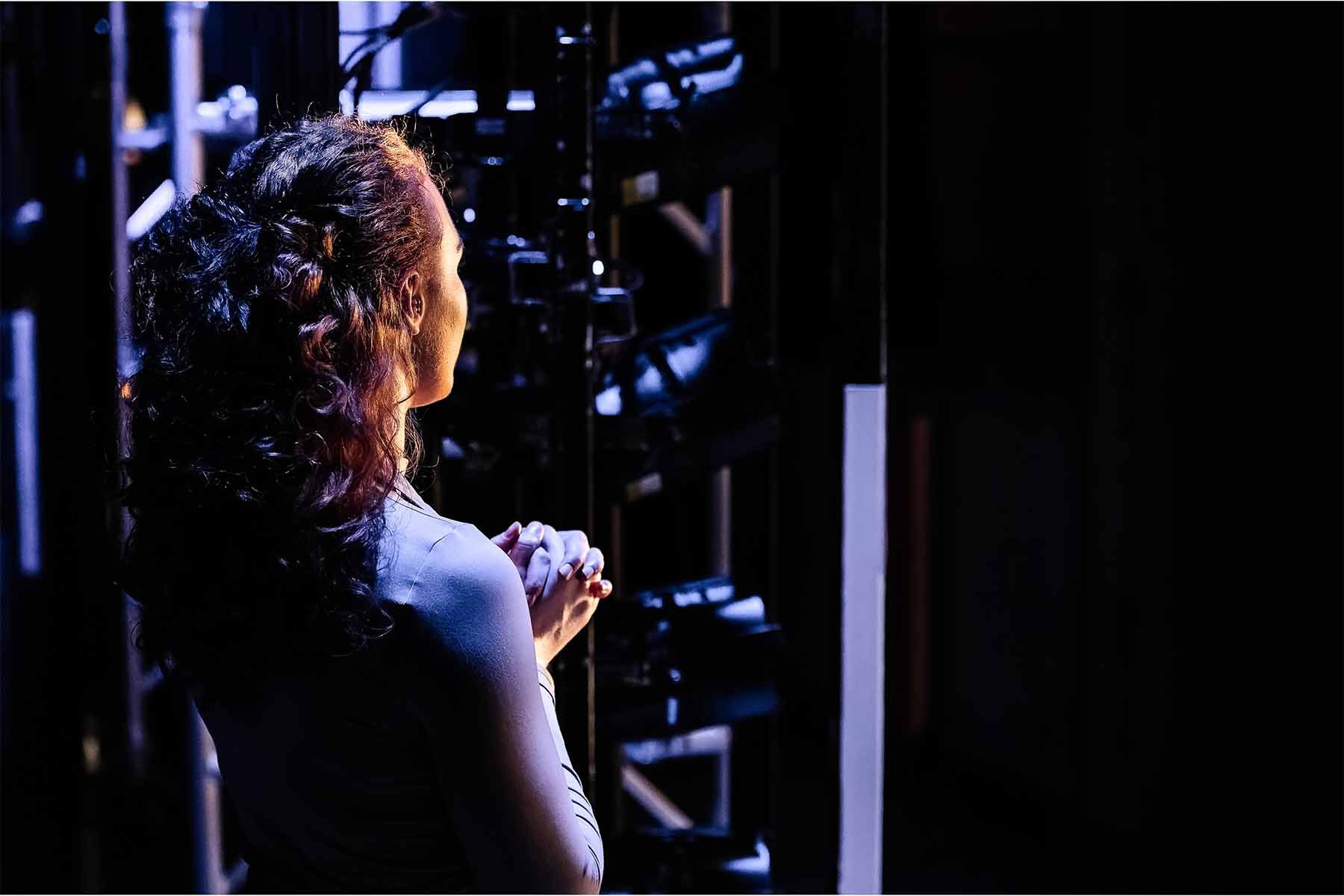A portrait of a woman facing away from the camera in thought