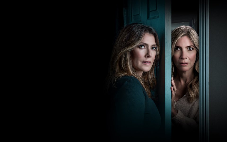 Two women standing either side of a door, they look scared