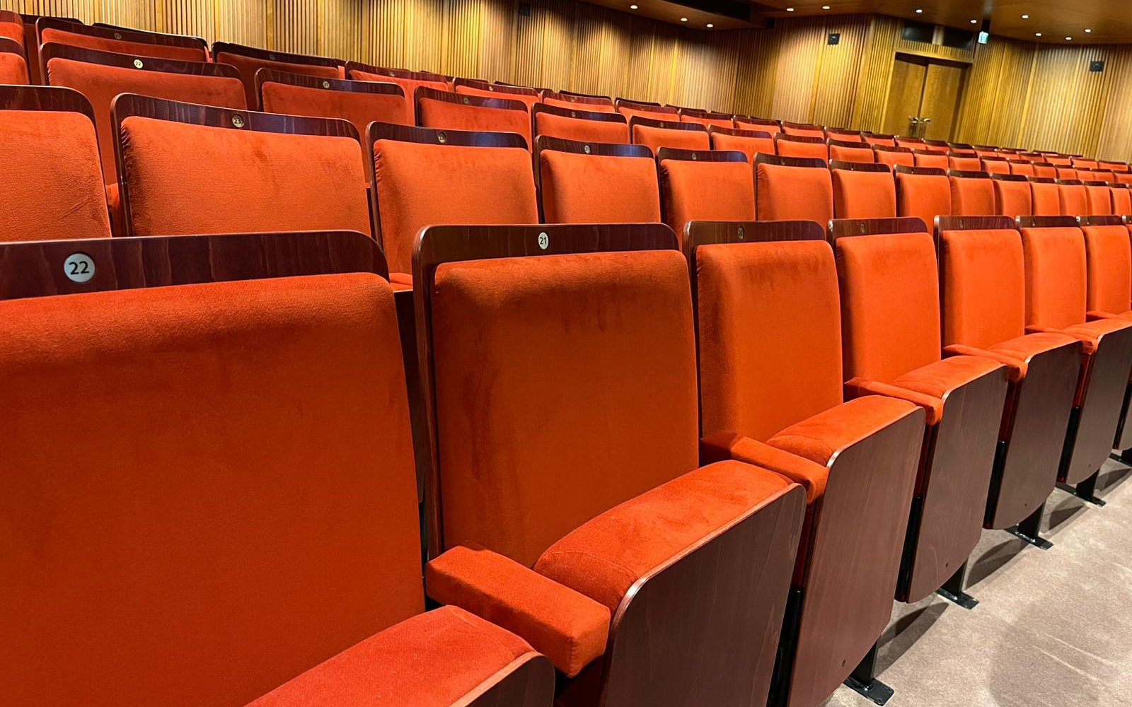 A close-up of one row of the new red seats in the auditorium.