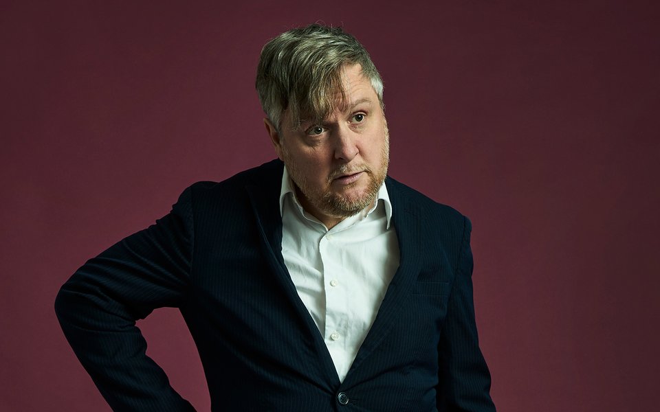 Tim Key wearing a white shirt and black jacket