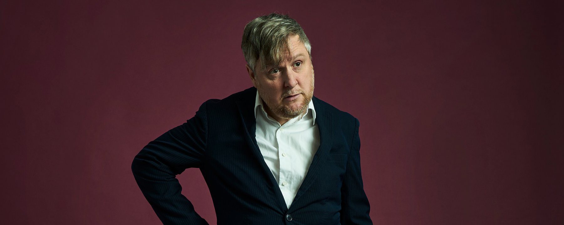 Tim Key wearing a white shirt and black jacket