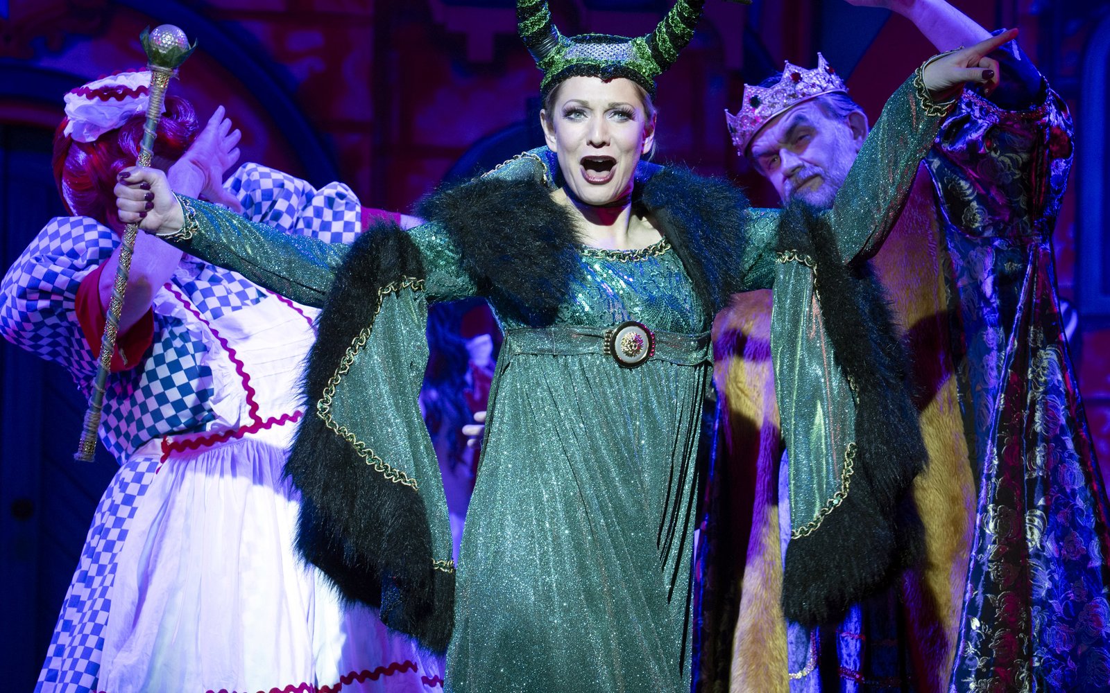 Carabosse wearing a sparkly green dress and black horns